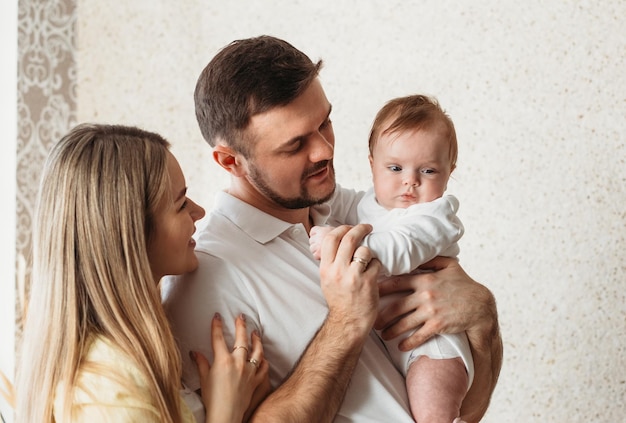 Bei giovani genitori che tengono la loro figlia sveglia del bambino