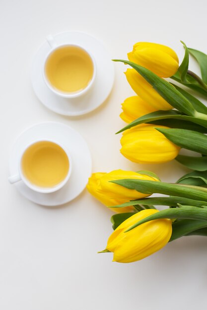 Bei tulipani gialli e tazze di tè calde