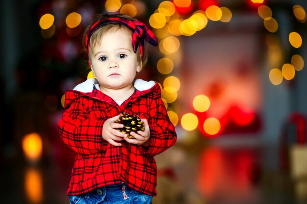 Bel bambino alla vigilia di Capodanno in mezzo a luci festive luminose incandescenti.