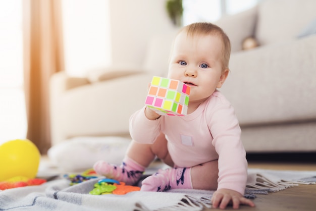 Bel bambino si siede sul pavimento e gioca con brillante.