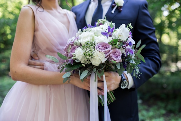 Bel bouquet da sposa in mano agli sposi