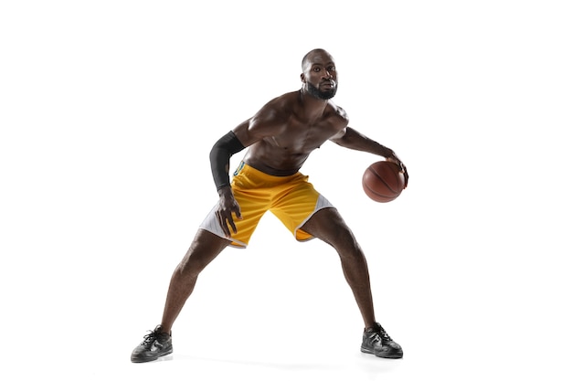 Bel giocatore di basket maschile in movimento e azione isolato su muro bianco