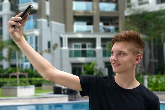 Bel giovane adolescente con capelli biondi all'aperto