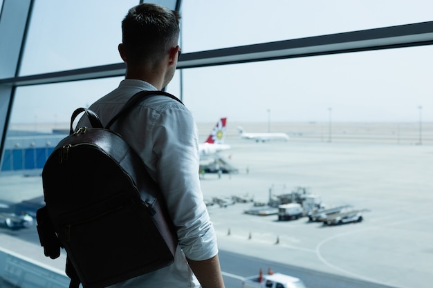 Bel giovane con uno zaino in aeroporto