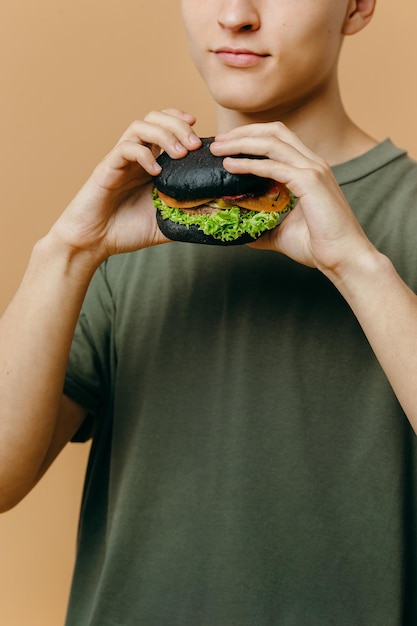 Bel giovane in posa con un hamburger su uno sfondo colorato