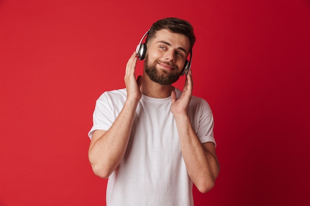 Bel giovane isolato musica d'ascolto con le cuffie.