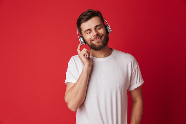 Bel giovane isolato musica d'ascolto con le cuffie.