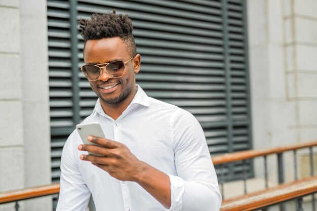 Bel giovane uomo africano in una camicia bianca