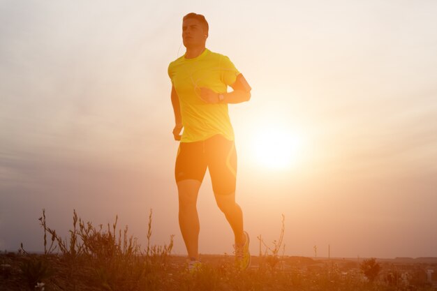 Bel giovane uomo che corre nel parco.