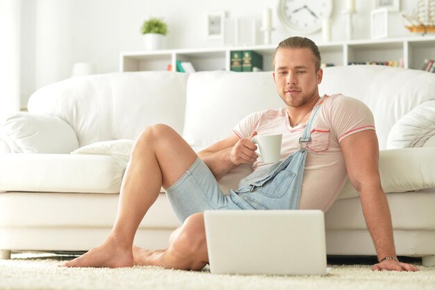 Bel giovane uomo con laptop