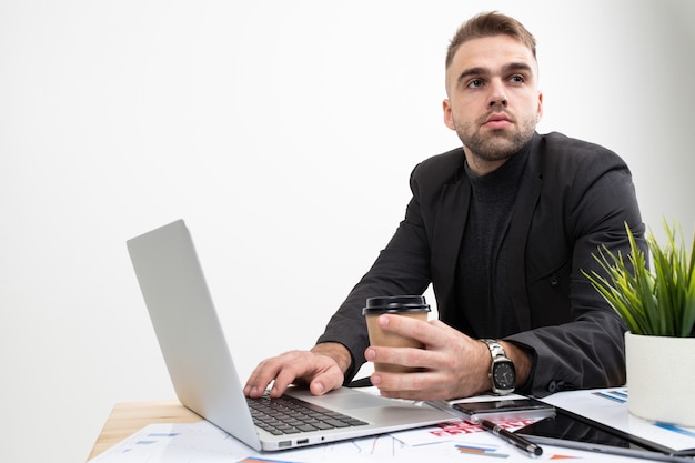 Bel giovane uomo d'affari che lavora su un computer portatile