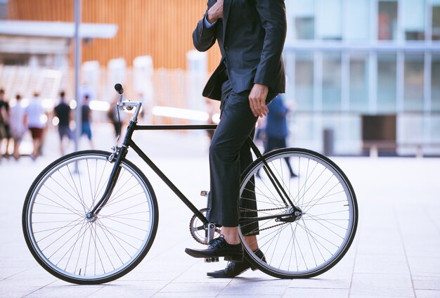 Bel giovane uomo d'affari con la sua bicicletta moderna.