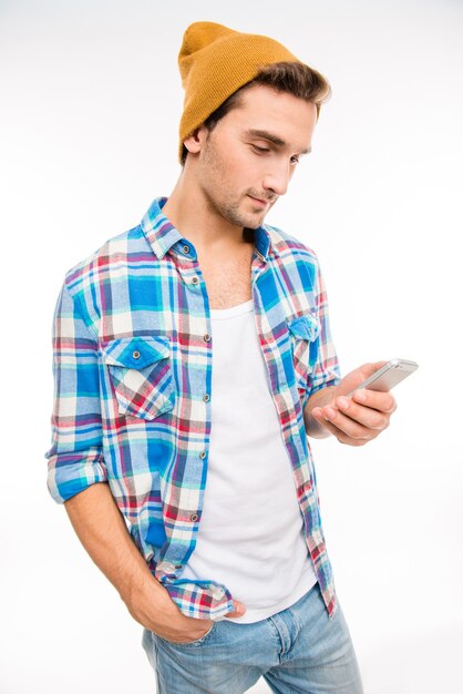 Bel giovane uomo in cappello giallo digitando un messaggio