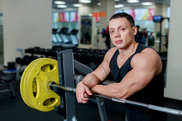 Bel giovane uomo muscoloso in palestra