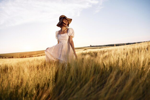 Bel paesaggio Bella giovane sposa in abito bianco è sul campo agricolo in giornata di sole