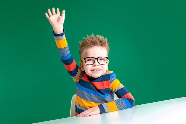 Bel ragazzo allegro con gli occhiali che agitano nella fotocamera Ciao