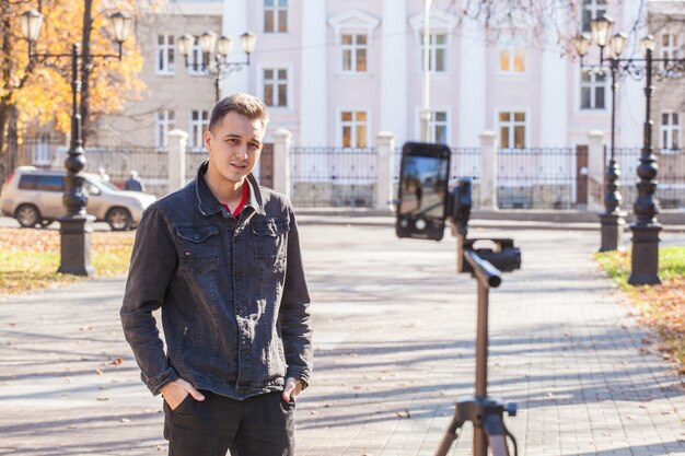 bel ragazzo blogger si toglie un treppiede per strada