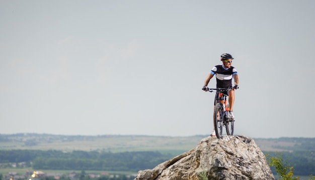 Bel ragazzo con la bici in cima alla montagna