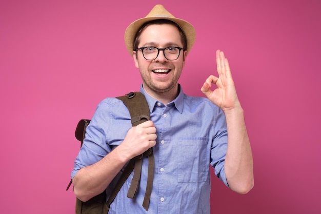 Bel sorriso amichevole turista caucasico uomo in cappello estivo che mostra ok