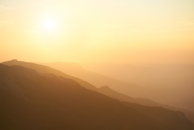 Bel tramonto in montagna. Paesaggio drammatico con sole e cielo arancione