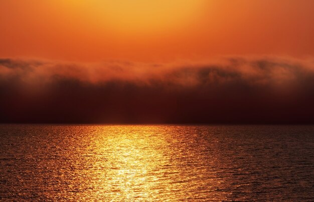 Bel tramonto rosso, nuvole scure e oceano atlantico all'orizzonte