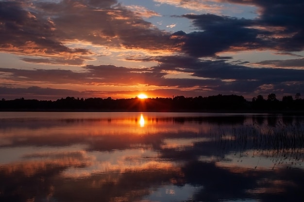 bel tramonto sugli alberi nel grande lago con cielo nuvoloso colorato in estate