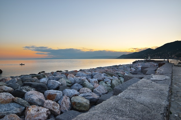 bel tramonto sul mare con cornice di pietre colorate