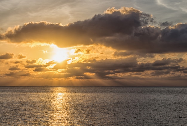 Bel tramonto sul mare con i raggi del sole attraverso le nuvole.