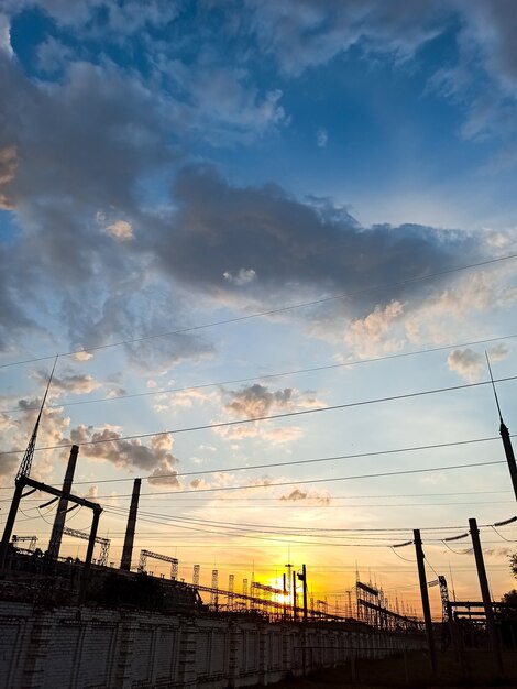 Bel tramonto sul paesaggio industriale, fabbrica, cavi elettrici, inquinamento, sullo sfondo di una natura meravigliosa.