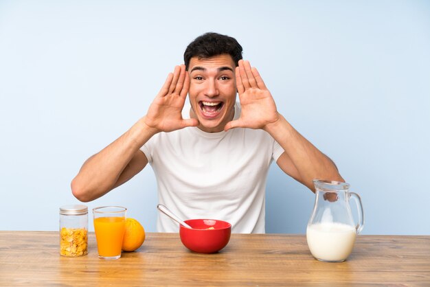 Bell&#39;uomo a fare colazione a gridare con la bocca spalancata