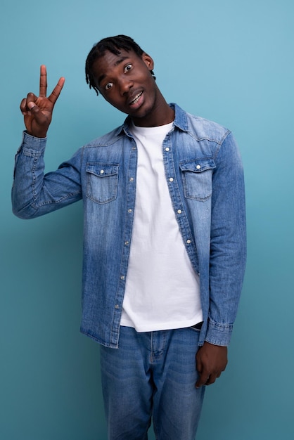 Bell'uomo africano con capelli ricci in giacca di jeans