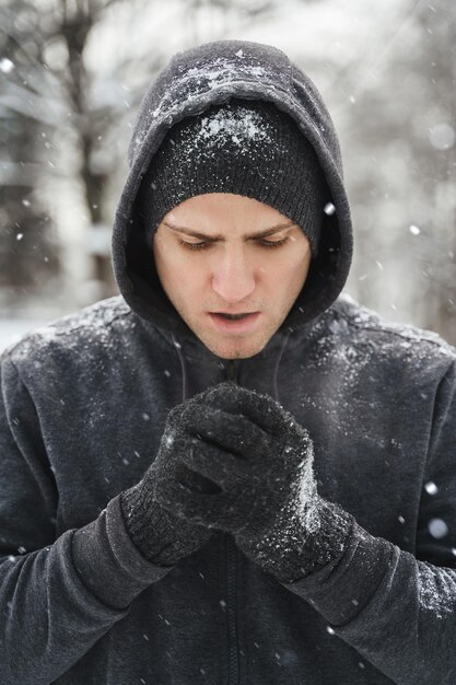 Bell'uomo atletico che indossa una felpa con cappuccio durante il suo allenamento invernale