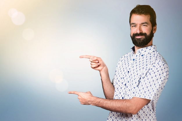 Bell&#39;uomo bruna con la barba che punta al laterale