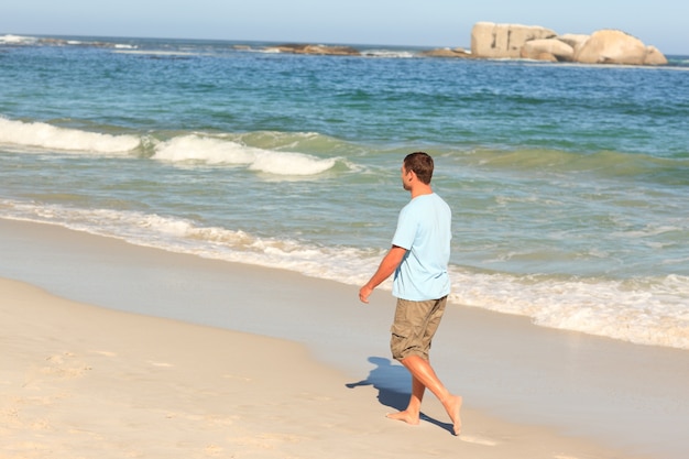 Bell&#39;uomo che cammina sulla spiaggia