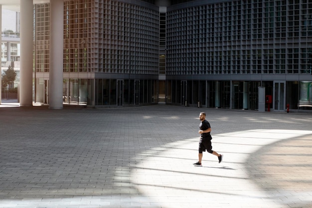 Bell'uomo che corre in città Ragazzo in abiti neri che conduce uno stile di vita sano