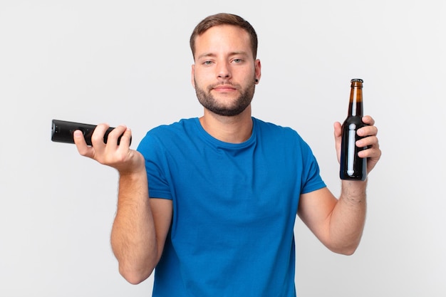 Bell'uomo che guarda la tv con una birra