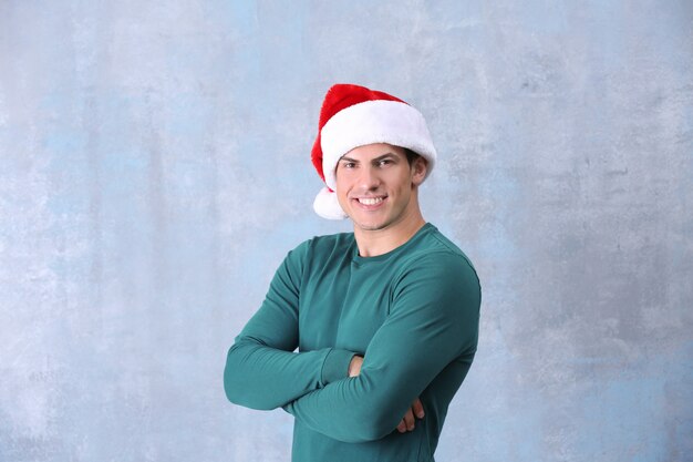 Bell'uomo con cappello di Natale su sfondo colorato