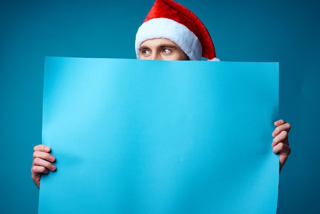 Bell'uomo con un cappello da Babbo Natale che tiene una posa in studio per le vacanze di banner