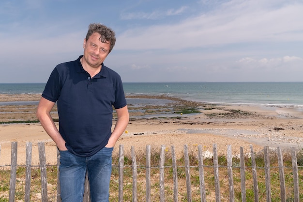 Bell'uomo felice in piedi sulla spiaggia di Isle de Re France