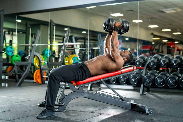 Bell'uomo forte che si allena duramente in palestra Bodybuider giovane attivo che si allena in palestra