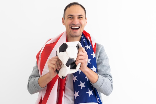 Bell'uomo giocatore che gioca a calcio tenendo la palla da calcio sullo sfondo con il viso a sorpresa che punta il dito verso se stesso. Foto di alta qualità