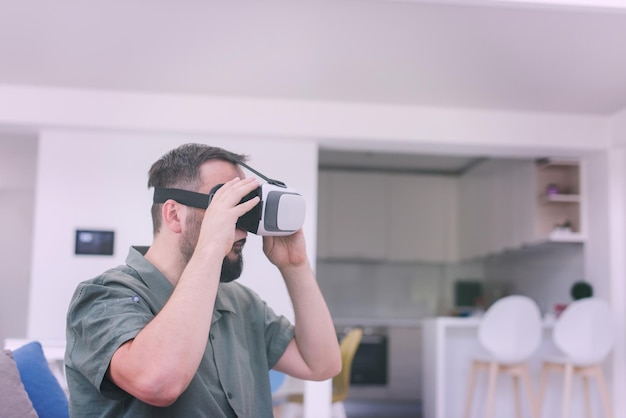 bell'uomo hipster con la barba che prova gli occhiali vr a casa moderna