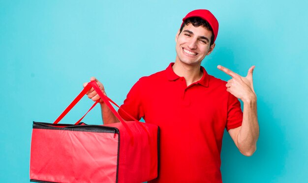 Bell'uomo ispanico che sorride con sicurezza indicando il proprio concetto di pizza di consegna ampio sorriso