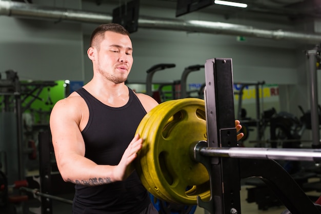 Bell'uomo muscoloso in palestra