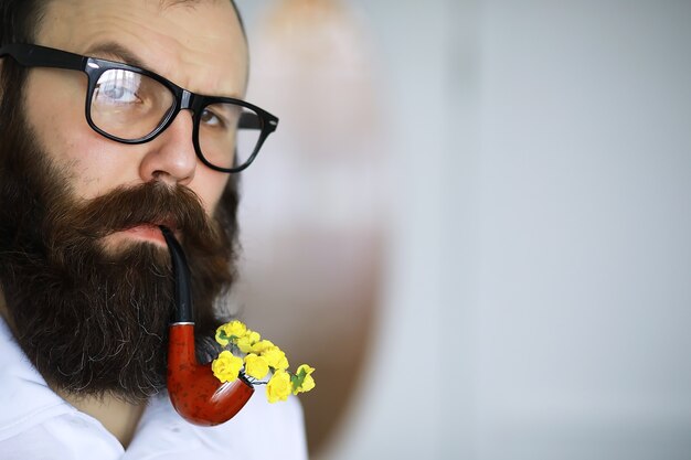 Bell'uomo o boscaiolo, hipster barbuto, con barba e baffi in camicia con pipa