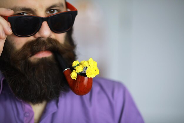 Bell'uomo o boscaiolo, hipster barbuto, con barba e baffi in camicia con pipa