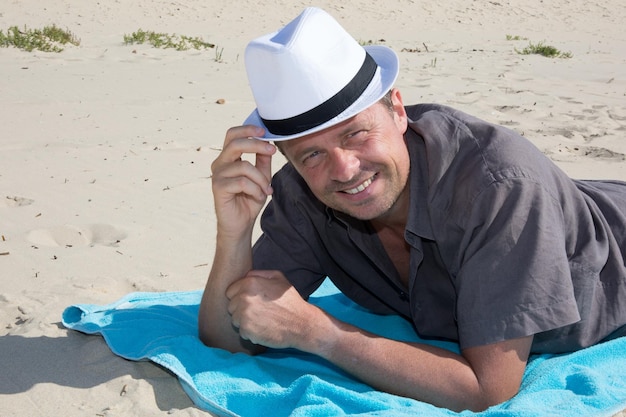 bell'uomo sdraiato sulla spiaggia di sabbia