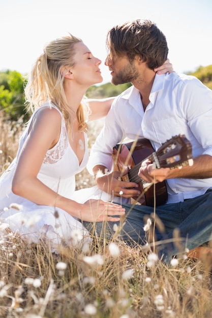 Bell&#39;uomo serenata la sua ragazza con la chitarra