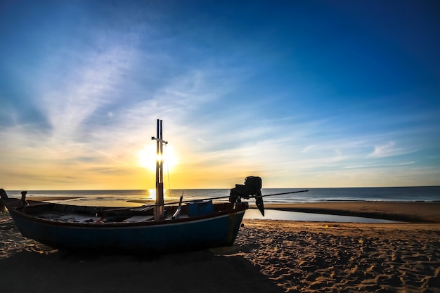 Bella alba tramonto sulla spiaggia con barca sagoma