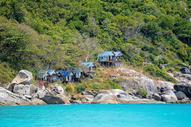 Bella baia con alberi verdi e vecchi bungalow in legno sulla montagna e sull'acqua di mare Thailandia